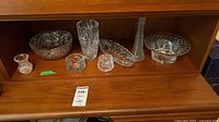 Shelf with seven clear cut glass/crystal tableware pieces displayed