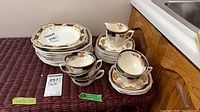 Stacked dinnerware showing plates, bowls, cups, saucers and creamer