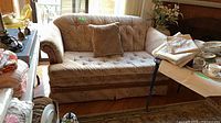 Full view of upholstered loveseat with pillow