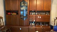 Full view of modular wall unit showing base credenza, upper cabinets, central glass display section and side shelves
