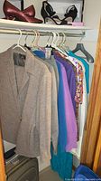 Closet rod with jackets, blouses, skirt, heels on shelf
