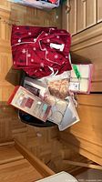 Overall lot view: pajama set, assorted boxed gift sets, sheet set and soaps in bin