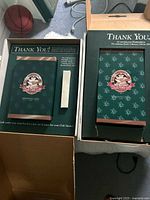 Two interior presentation boxes marked Thank You with club inserts visible