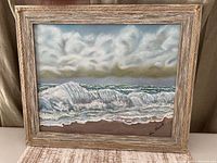 Front view of framed seascape painting showing artwork, frame and signature