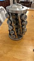 Full view of metal revolving spice rack with jars