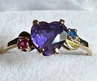 Front view of ring showing heart-shaped amethyst and side stones