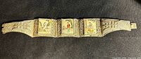 Full view of silver filigree bracelet showing four painted panels and clasp