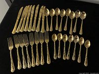 Full layout of 31 gold plated flatware pieces