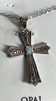 Cross pendant on chain in display card highlighting opal and sterling silver