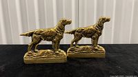 Front view of both brass dog bookends showing design and inscription