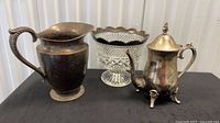 Group shot of silver plate pitcher, crystal pedestal bowl, and silver plate teapot