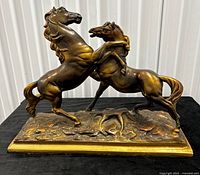 Full view of bronze and gold-tone ceramic statue of two rearing stallions on base