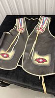 Front of leather vest with beadwork, pockets, ties visible