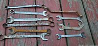All nine wrenches laid out on wooden surface