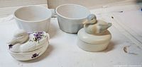 Lot overview showing two white ramekin bowls and two duck-topped trinket dishes