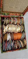 Open box showing organised stacks of assorted bangles