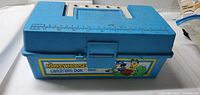 Closed tackle box showing Mickey Mouse label and ruler