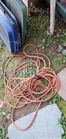 Coiled orange air hose on ground