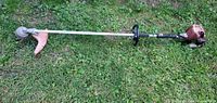 Full view of Stihl FS 800 gas string trimmer laying on grass