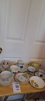 Overall lot view showing all teacups, saucers, and plates on tray table