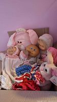 Group shot of dolls, plush bunnies and clothing