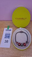 Bracelet with charms in Chamilia box alongside lot tag