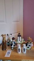entire assortment of cow figurines, lighthouse, cat and shakers