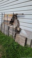 Front view of stacked lumber against siding