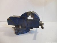 Side view of blue Mastercraft 4" bench vise showing swivel base and anvil