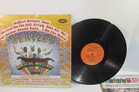 Front cover of Magical Mystery Tour album in shrink wrap next to vinyl record