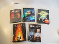 Five DVD box sets laid out on table, all titles visible