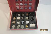 Open case showing 20 labeled rock specimens and magnifier