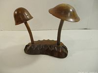 Front view showing two mushroom stems and pierced caps