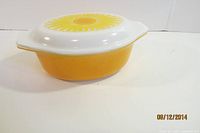 Side view of yellow-orange casserole with white lid
