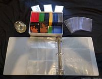 Full lot overview showing binder, box of sleeves, top loaders, baseball display