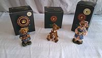 Front view of three Boyds Bearstone figurines with their boxes