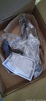 Ceiling light fixture components in box with instruction sheet and packaging
