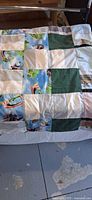 Full view of patchwork quilt draped over surface showing overall pattern and size