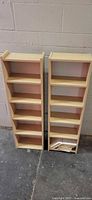 Two matching light wood media tower shelves front view