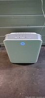 Front view of GermGuardian air purifier powered on showing blue LED ring