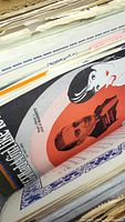 Stacks of vintage sheet music showing colorful illustrated covers