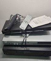 Stack of three Sony components with two remotes and manuals on top