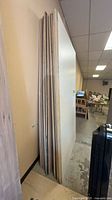 Stack of plywood and melamine sheets leaning against wall