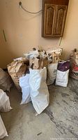 Multiple bags filled with scrap wood pieces against wall