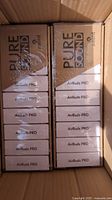 Open shipping box showing two display trays of sealed Accent Pure Sound Airbuds Pro boxes