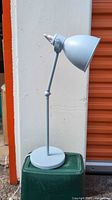 Full side view showing light blue adjustable desk lamp on base