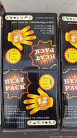 Two retail display boxes of Heat Pack body warmers showing 12-hour claim and graphics