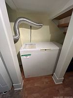 Full view of white Beaumark chest freezer under stairs