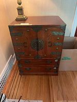 Front view showing cabinet doors, drawers, and iron hardware