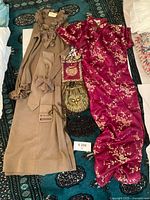 Sport Couture tan ruffle top with belt beside floral Cheongsam